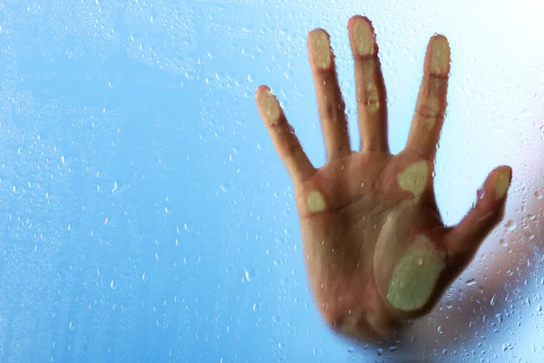 Female hand behind wet glass — Stock Photo, Image