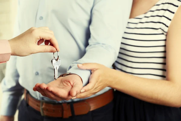 Onroerende goederenagent sleutels geven jong koppel — Stockfoto