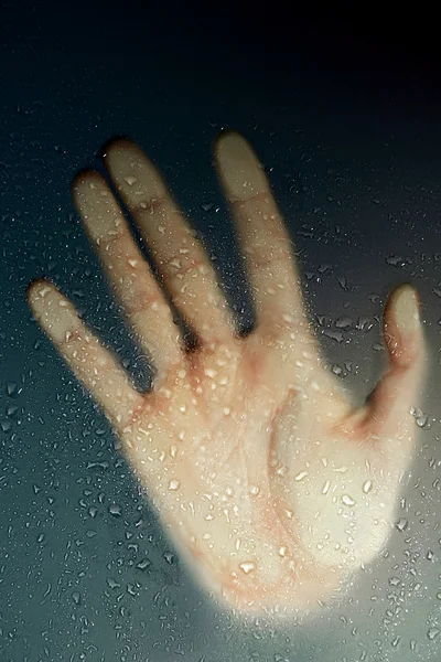 Γυναικείο χέρι πίσω από το υγρό γυαλί — Φωτογραφία Αρχείου