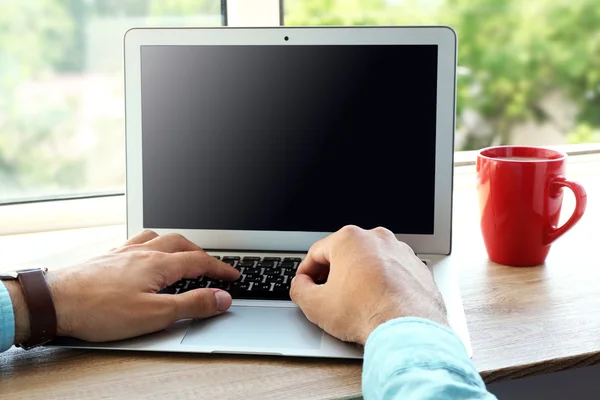 Man som arbetar med laptop i kontor nära fönster — Stockfoto