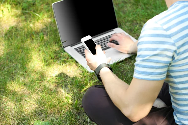 Young man with laptop outdoors — Stock Photo, Image