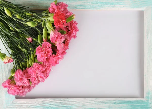 Schöner Strauß rosa Nelke mit Holzrahmen isoliert auf weiß — Stockfoto