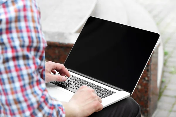 Giovane uomo con computer portatile all'aperto — Foto Stock