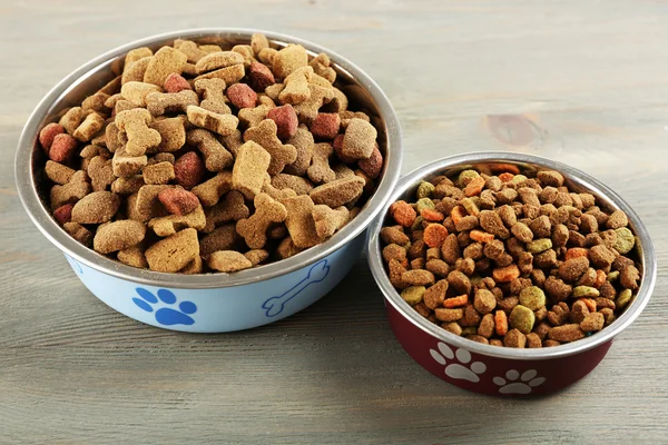 Comida para perros en cuencos sobre mesa de madera — Foto de Stock