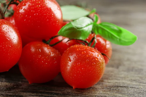 Tomates cherry con albahaca sobre mesa de madera de cerca —  Fotos de Stock