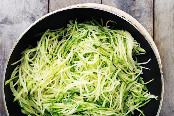 Grated zucchini and squash in pan on wooden table close up — Stock Photo, Image