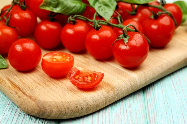 Fresh tomatoes with basil on wooden table close up — Stock Photo, Image