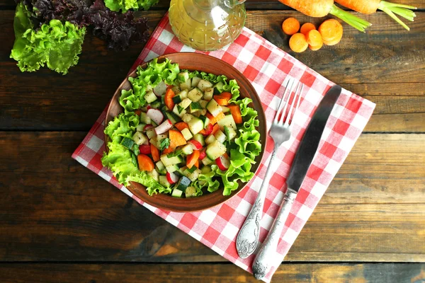 Ciotola di legno di insalata di verdure fresche sul tavolo di legno, vista dall'alto — Foto Stock