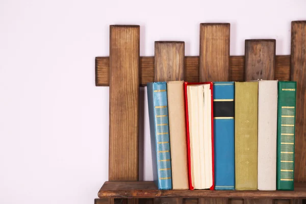 Rak kayu dengan buku di latar belakang dinding — Stok Foto