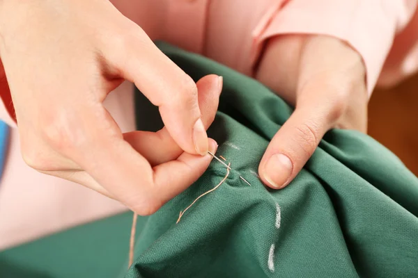 Mãos fechadas de costureira no trabalho com tecido de tecido — Fotografia de Stock