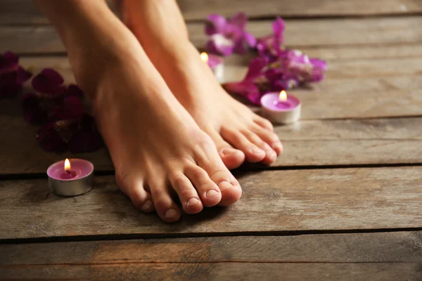 Feet at spa pedicure procedure with flowers — Stock Photo, Image