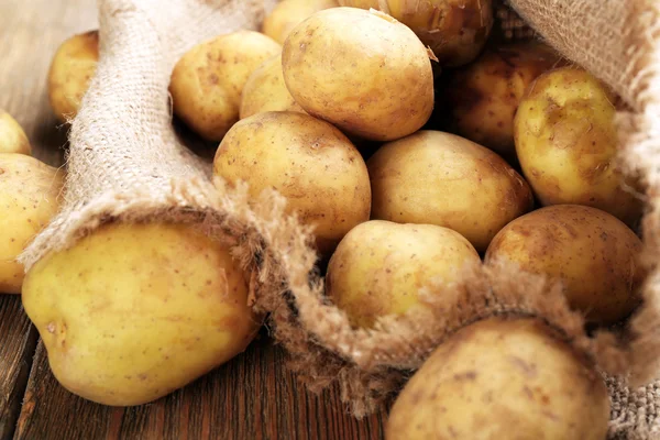 Batatas jovens na mesa de madeira — Fotografia de Stock