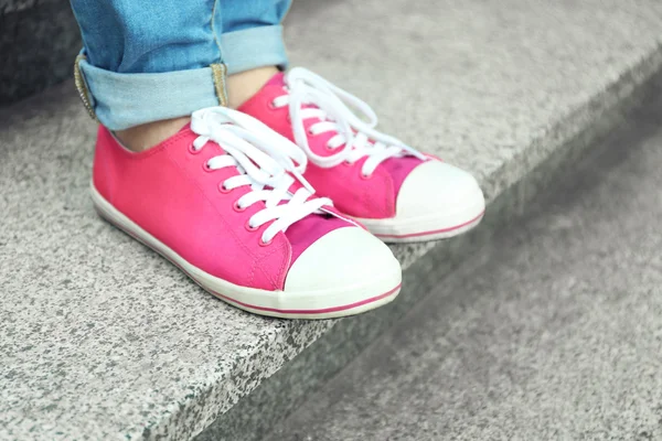 Vrouwelijke voeten in roze gumshoes — Stockfoto
