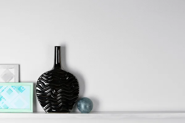 Modern vase with picture on shelf in room — Stock Photo, Image