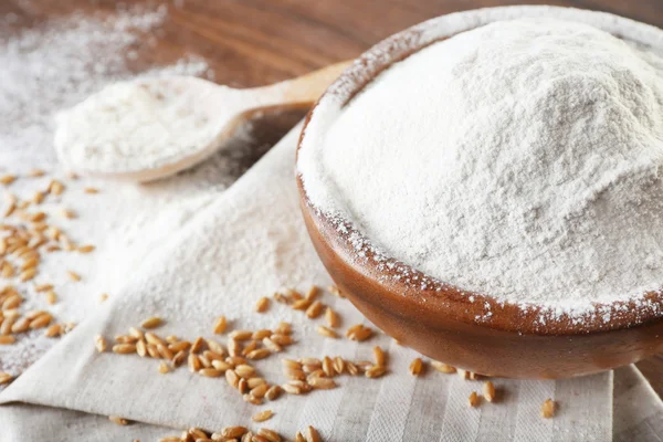 Whole flour with wheat on wooden table, closeup — Stock Photo, Image