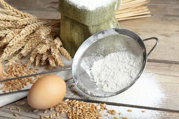 Flour and wheat on wooden table — Stock Photo, Image