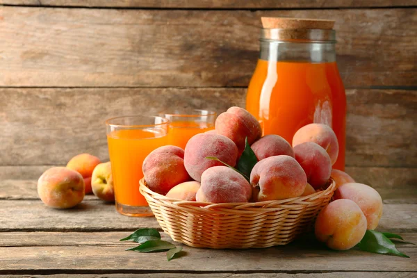 Mogna persikor och juice på trä bakgrund — Stockfoto