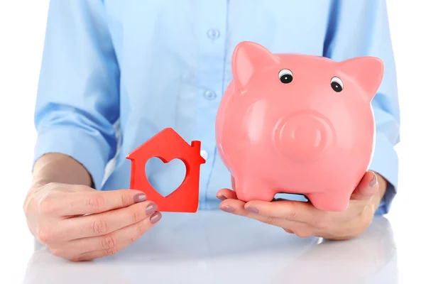 Handen met piggy bank en huis — Stockfoto