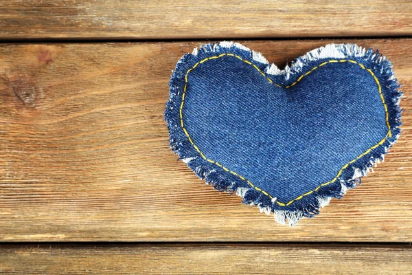 Джинсовое сердце на деревянном фоне — стоковое фото