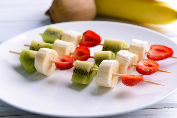 Frutas frescas en pinchos en plato — Foto de Stock