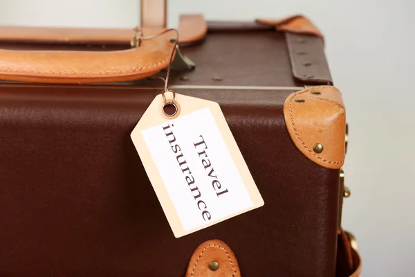 Suitcase with TRAVEL INSURANCE label — Stock Photo, Image