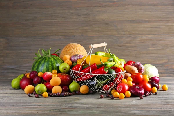 Heap av färska frukter och grönsaker på trä bakgrund — Stockfoto