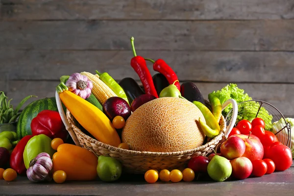 Oogsten van verse groenten en fruit op houten ondergrond — Stockfoto