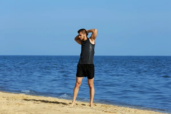 Young man sporty doing exercise on beach Stock Photo