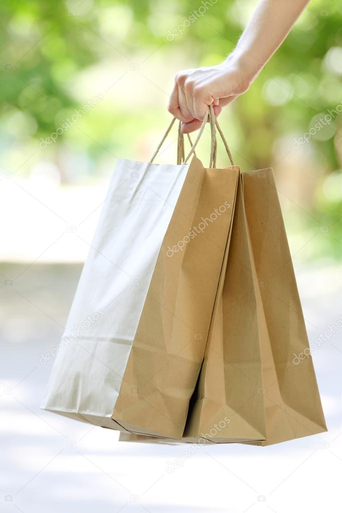 Female hand holding shopping bags outdoors