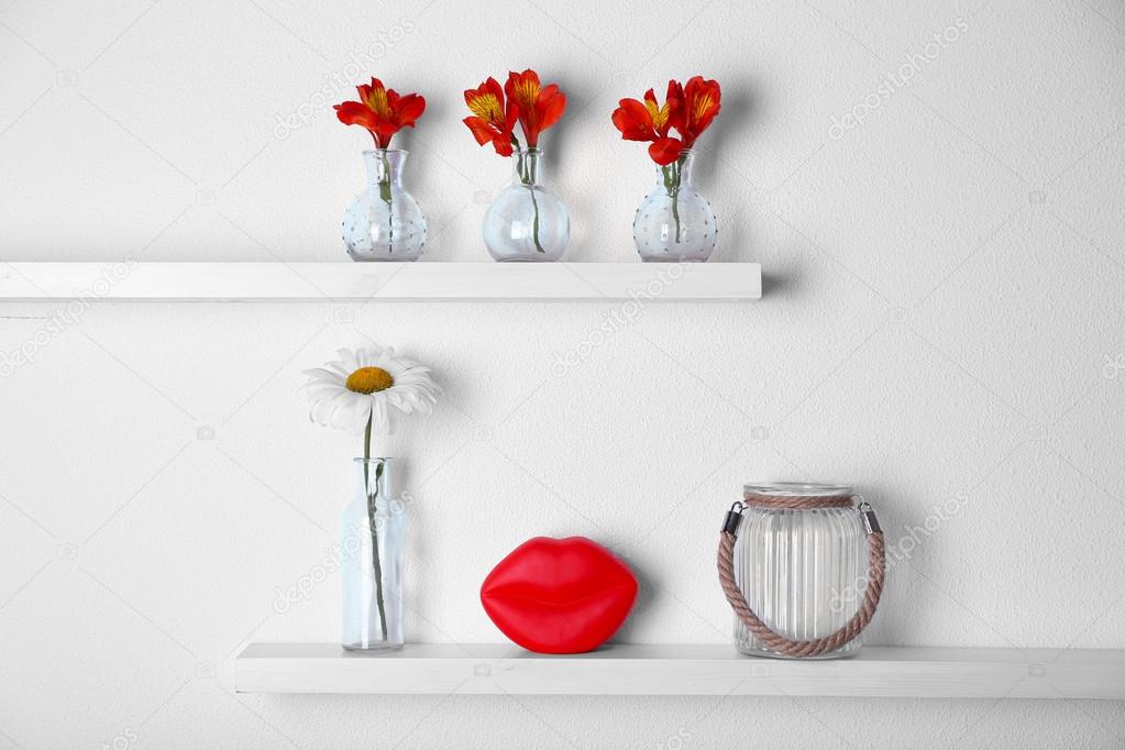 Decorative glass vases with flowers on wooden shelf — Stock Photo