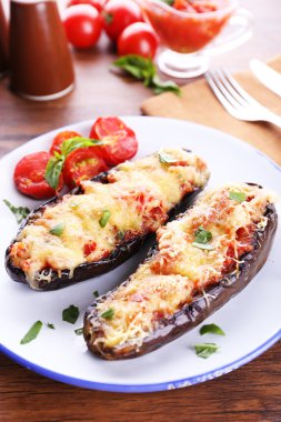 Patlıcan kiraz domates ve peynirle ahşap masa, closeup üzerinde beyaz tabakta yemek