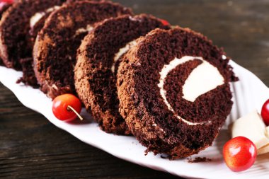 Lezzetli çikolata rulo beyaz tabak içinde ahşap masa, portre