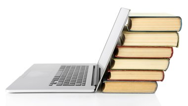 Kitap üzerinde beyaz izole dizüstü bilgisayar ile yığını
