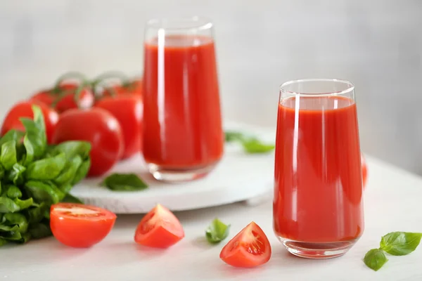 Tomatensaft und frische Tomaten auf Holztisch in Großaufnahme — Stockfoto