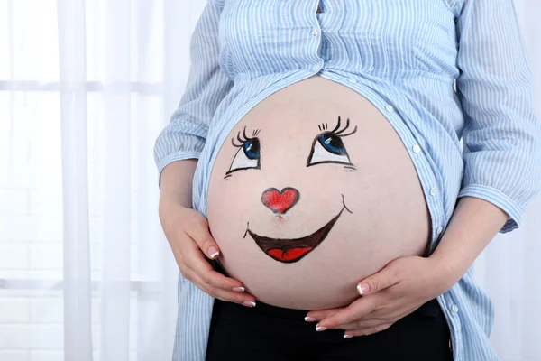 Zdobení těla na břicho těhotné ženy na světlé pozadí — Stock fotografie