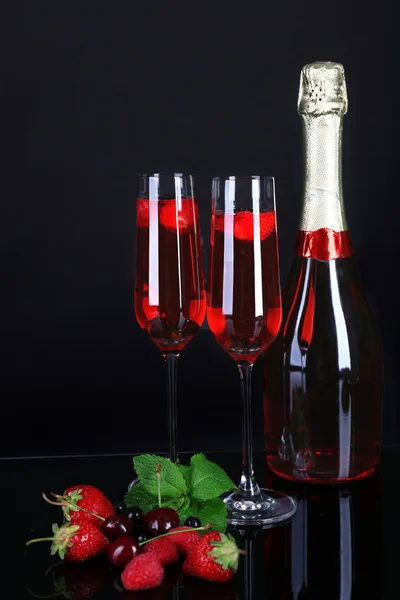 Sklenice šampaňského s plody na černém pozadí — Stock fotografie