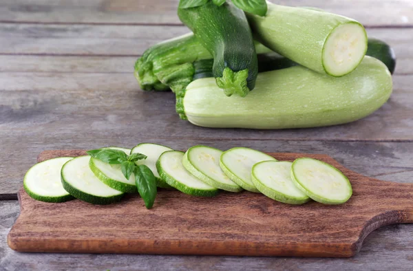 Fresh zucchini with squash and basil on wooden table close up — Stock Photo, Image