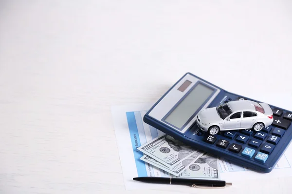 Speelgoedauto, geld, documenten en Rekenmachine op tafel. Auto verzekering concept — Stockfoto