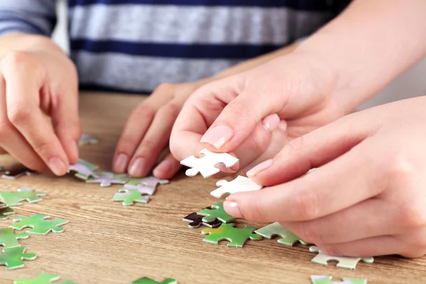 Mains féminines assemblage puzzle — Photo