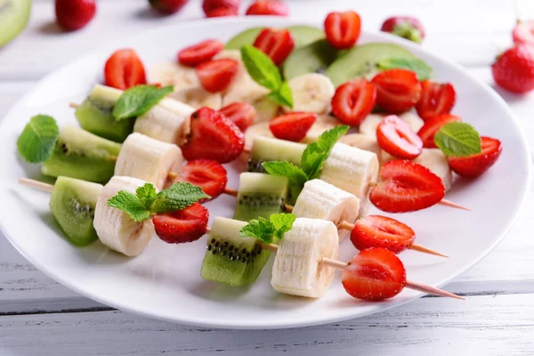 Frutta fresca su spiedini in piatto — Foto Stock