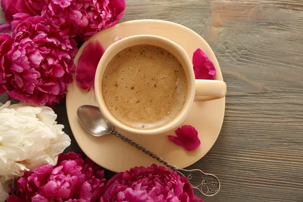 Cup of coffee and peony flowers — Stock Photo, Image
