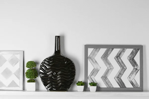 Vase with picture on shelf in room — Stock Photo, Image