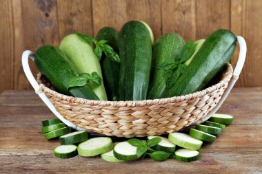 Squash ve hasır sepet ahşap arka plan üzerinde fesleğen taze kabak