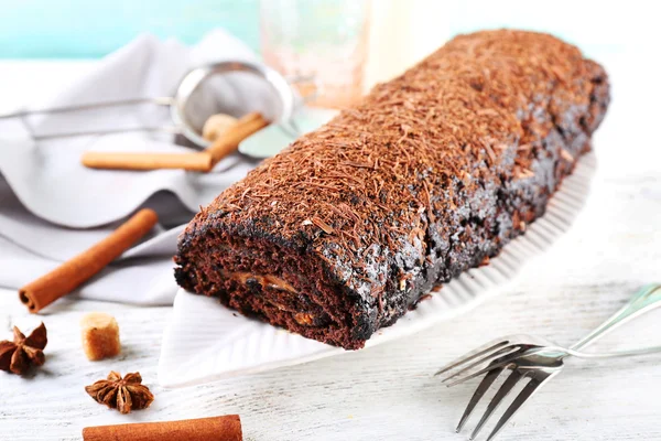 Délicieux rouleau de chocolat aux épices sur table en bois, gros plan — Photo