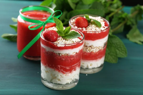 Postre con fresa fresca, crema y granola, sobre fondo de mesa de madera de color —  Fotos de Stock