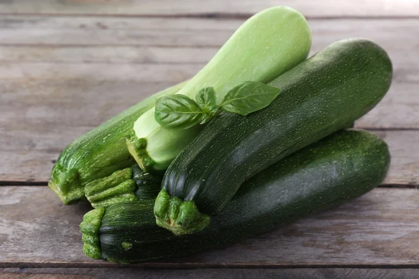 Färsk zucchini med squash och basilika på träbord nära håll — Stockfoto