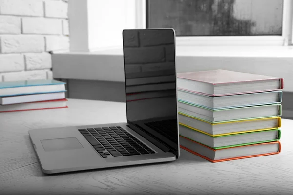 Bücherstapel mit Laptop auf dem Tisch — Stockfoto