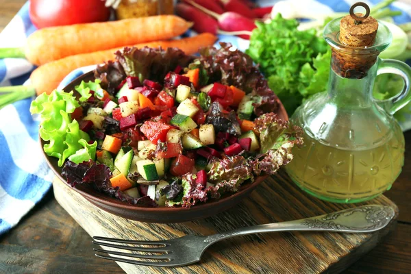 Trä skål med färska grönsaker sallad på bordet, närbild — Stockfoto