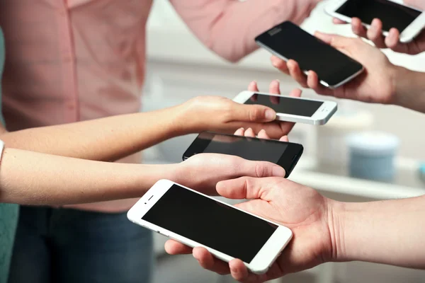 Muchas manos sosteniendo teléfonos móviles — Foto de Stock