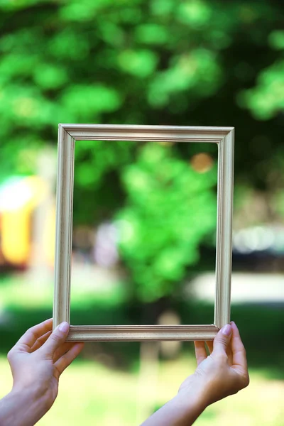 Female hands with wooden frame — Stock Photo, Image